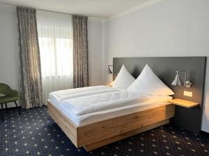a bedroom with a large bed with a wooden frame at stadthotel miya in Bad Mergentheim +14 photos