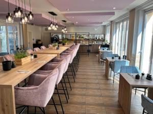 a row of tables and chairs in a restaurant at stadthotel miya in Bad Mergentheim