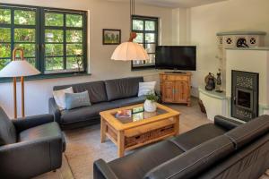 a living room with couches and a tv at Strandhaus Ahrensh 1 in Ahrenshoop