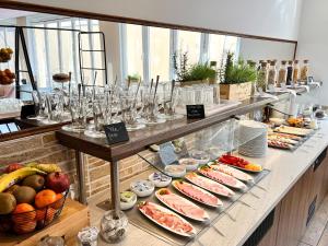 a buffet line with glasses and food on display at stadthotel miya in Bad Mergentheim