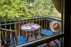 a table and chairs on a balcony with a hat at Strandhaus Ahrensh 1 in Ahrenshoop