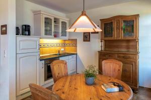 a kitchen with a wooden table and a sink at Strandhaus Ahrensh 2 in Ahrenshoop