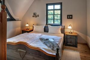 a bedroom with a bed and two lamps and a window at Strandhaus Ahrensh 2 in Ahrenshoop