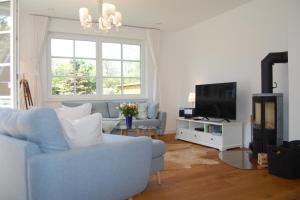 a living room with a blue couch and a tv at Min Droom in Wustrow