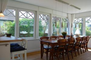 a dining room with a table and chairs and windows at Min Droom in Wustrow