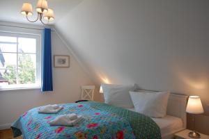 a bedroom with a bed with two towels on it at Min Droom in Wustrow
