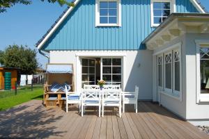 a deck with a table and chairs on a house at Min Droom in Wustrow