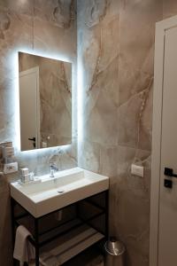 a bathroom with a sink and a mirror at Zoe Boutique Hotel in Durrës +100 photos