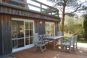 a patio with a table and chairs on a deck at Sonnendeck in Born