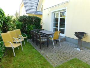 a patio with a table and chairs and a grill at Haus Sonnenschein 2 in Ahrenshoop