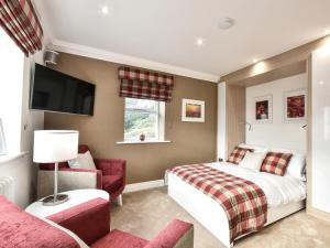 a bedroom with a bed and a couch and a tv at 6 Bed in Otley oc-g0022 in Fewston
