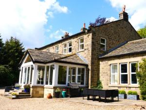 a large brick house with a conservatory at 6 Bed in Otley oc-g0022 in Fewston