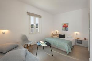 a white room with a bed and a couch at Irini's Poiēma in Lefkes