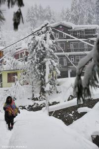 a person walking in the snow next to a ski lift at North star Manali in Vashisht