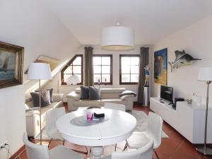 a living room with a white table and chairs at Boje Haus Sanddorn in Althagen