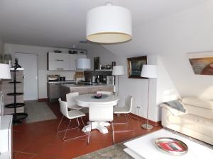 a kitchen and living room with a table and chairs at Boje Haus Sanddorn in Althagen +3 photos