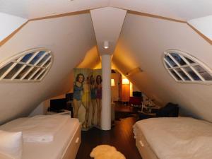 a attic room with two beds and two windows at Boje Haus Sanddorn in Althagen