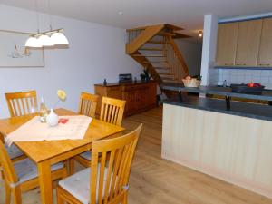 a kitchen and dining room with a wooden table with chairs at Malergarten 14 in Ahrenshoop