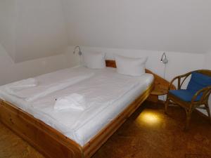 a bed in a room with a blue chair and a bed sidx sidx at Malergarten 14 in Ahrenshoop