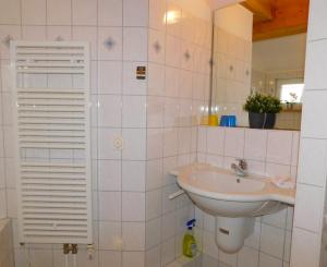 a white bathroom with a sink and a mirror at Malergarten 14 in Ahrenshoop +4 photos