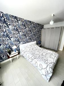 a bedroom with a bed and a blue and white wallpaper at La maison de La Combe in Parzac