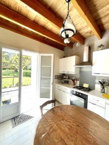 a kitchen with a wooden ceiling and a table at La maison de La Combe in Parzac