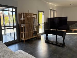 a living room with a tv and a piano at Aharon boutique suite in Pardes H̱anna