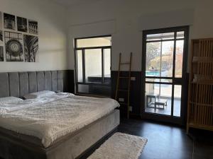 a bedroom with a bed and a sliding glass door at Aharon boutique suite in Pardes H̱anna +22 photos