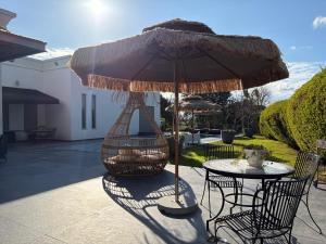 a table and chairs under an umbrella on a patio at Aharon boutique suite in Pardes H̱anna