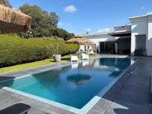 a swimming pool with chairs and a house at Aharon boutique suite in Pardes H̱anna