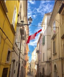 an alley with flags hanging between two buildings at La casa gialla in Campobasso