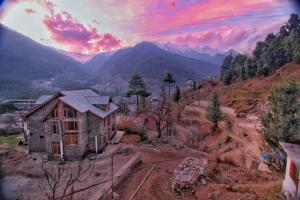 a house on a hill with mountains in the background at North star Manali in Vashisht