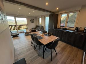a living room with a wooden table and chairs at Le Chalet de la belle vue in Fouchy