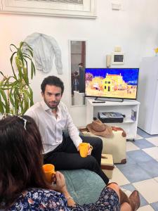 a man and a woman sitting in a living room at La casa gialla in Campobasso