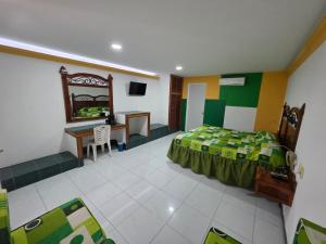 a bedroom with a bed and a desk and a table at Hotel Los Cedros in Martínez de La Torre
