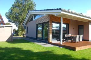 a house with a deck with a table and chairs at Sanddornhus in Ahrenshoop