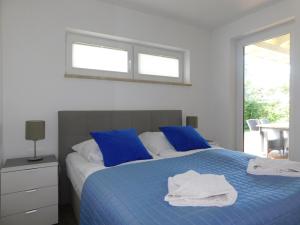 a bedroom with a blue bed with blue pillows at Sanddornhus in Ahrenshoop