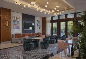 a restaurant with tables and chairs in a room at Cameo Beverly Hills, LXR Hotels & Resorts in Los Angeles