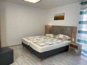 a bedroom with a bed with a wooden headboard at Schäfer Apartments in Oberderdingen
