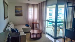 a living room with a couch and a room with a balcony at VISTA ESPETACULAR - TWIN TOWERS - Barra da Tijuca in Rio de Janeiro