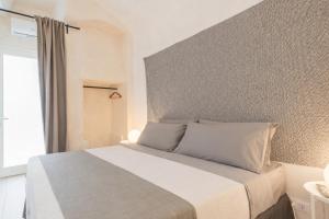 a bedroom with a white bed with a window at Sunny Vibes Monopoli in Monopoli