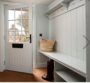 a hallway with a white door and a shelf with a basket at Hoolet's View, East Lothian in Whittingehame