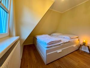 a small bedroom with a bed in a attic at Malergarten 05 in Ahrenshoop