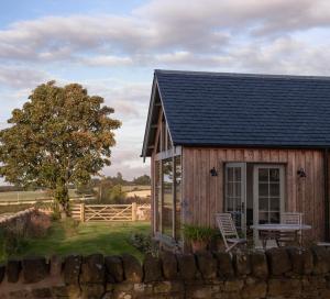 a small wooden cabin with a table and chairs outside at Hoolet's View, East Lothian in Whittingehame +5 photos