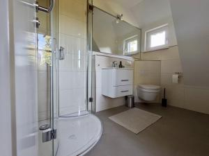 a bathroom with a shower and a sink and a toilet at Malergarten 05 in Ahrenshoop