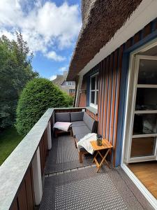 a patio with a couch and a table on a balcony at Malergarten 05 in Ahrenshoop