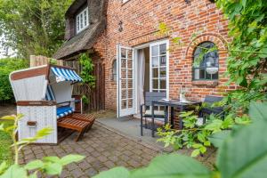 a brick house with a bench and a table at Altstadttor 17 in Westerland