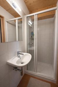 a bathroom with a sink and a shower at Penthouse duplex with sauna & mountain views in Pontresina +9 photos