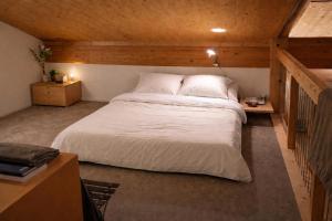 a bedroom with a large white bed in a attic at Penthouse duplex with sauna & mountain views in Pontresina
