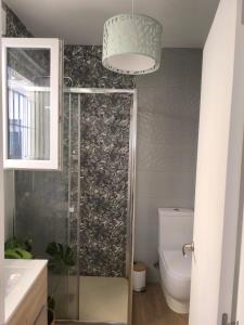 ein Badezimmer mit Toilette und Kronleuchter in der Unterkunft La Camera in Camas